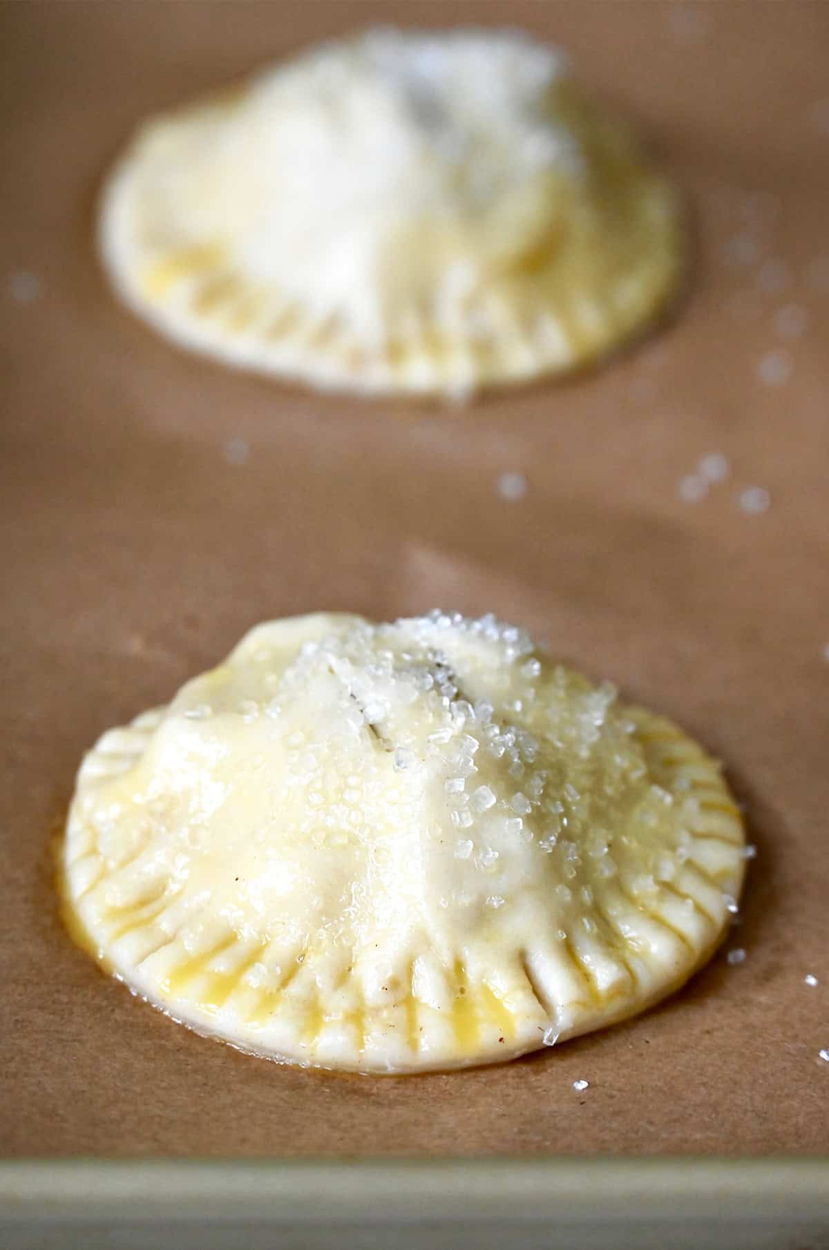 Unbaked hand pies topped with sanding sugar.