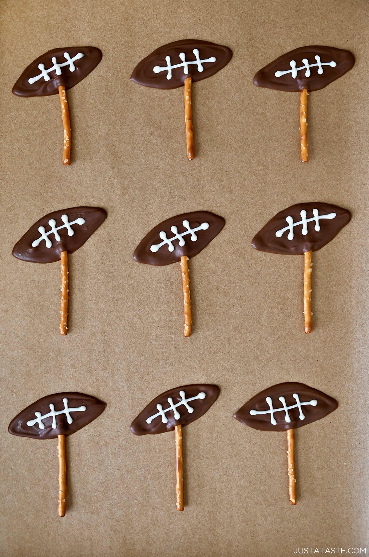 Chocolate footballs piped onto pretzel sticks